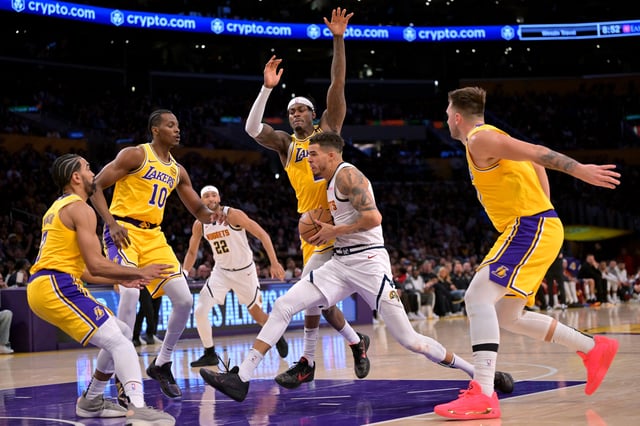 Mar 19, 2025; Los Angeles, California, USA;   Los Angeles Lakers center Christian Koloko (10), guard Gabe Vincent (7), forward Jarred Vanderbilt (2) and guard Luka Doncic (77) defend a drive by Denver Nuggets forward Michael Porter Jr. (1) in the second half at Crypto.com Arena. Mandatory Credit: Jayne Kamin-Oncea-Imagn Images