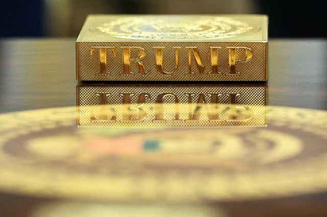 A gold coaster reading &#34;TRUMP&#34; sits on the table in front of US President Donald Trump as he meets with Irish Prime Minister Micheal Martin in the Oval Office of the White House in Washington, DC, on March 12, 2025.
