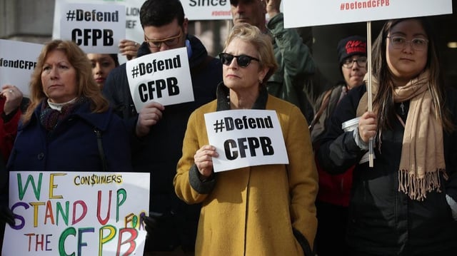 Protesters express their disappointment with President Trump&#39;s pick to head the Consumer Financial Protection Bureau, an official who once called the agency &#34;a sick, sad joke.&#34;