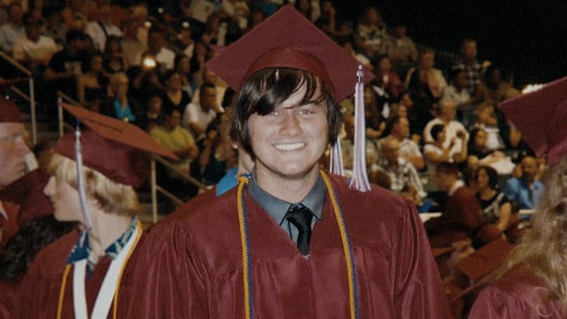 Will Norton smiles in his graduation gown