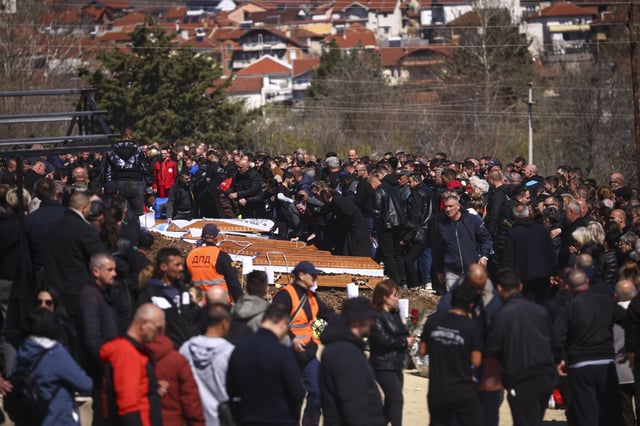 A woman cries leaning on a coffin as people gather at a cemetery for the funeral ceremony of the victims of a massive nightclub fire in the town of Kocani, North Macedonia, Thursday, March 20, 2025. (AP Photo/Armin Durgut)