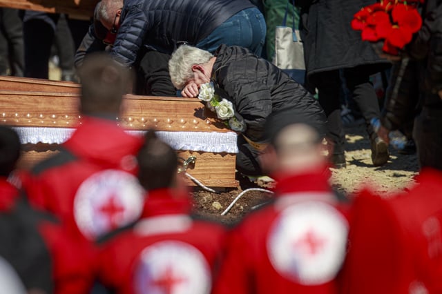 A person cries leaning on a coffin during the funeral ceremony of the victims of a massive nightclub fire in the town of Kocani, North Macedonia, Thursday, March 20, 2025. (AP Photo/Visar Kryeziu)