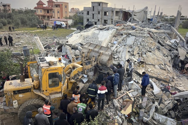 Volunteers and rescue workers use a bulldozer as to remove the rubble of a building hit by an Israeli army airstrike in Khan Younis, southern Gaza Strip, Thursday, March 20, 2025. (AP Photo/Mariam Dagga)