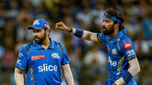 Mumbai Indians' captain Hardik Pandya (R) gestures as Rohit Sharma looks on