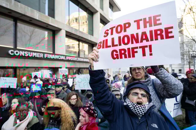 Demonstrators hold signs as they attend a protest against President Donald Trump and Elon Musk's anticipated plan to close the Consumer Financial Protection Bureau (CFPB) in front of the CFPB headquarters in Washington, D.C., on February 10, 2025.