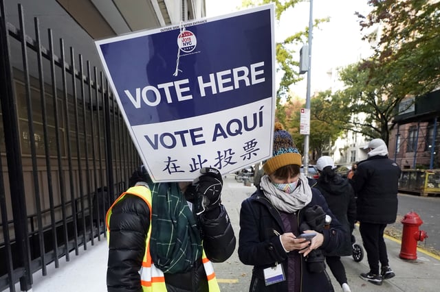 FILE — Poll workers direct voters outside Frank McCourt High School on New York's Upper West Side, Nov. 3, 2020. (AP Photo/Richard Drew, File)