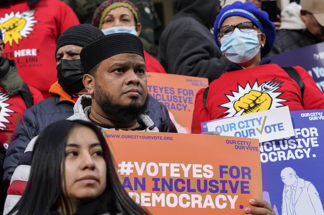 FILE - Activists participate in a rally on the steps of New York City Hall ahead of a City Council vote to allow lawful permanent residents to cast votes in elections to select the mayor, City Council members and other municipal officeholders, Dec. 9, 2021. (AP Photo/Mary Altaffer, File)