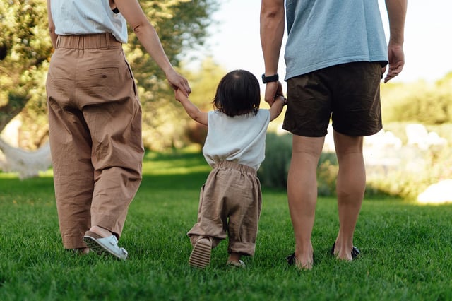 Cropped shot of young Asian family having fun in tourist resort with sunlight. Family vacation. Happy family portrait.