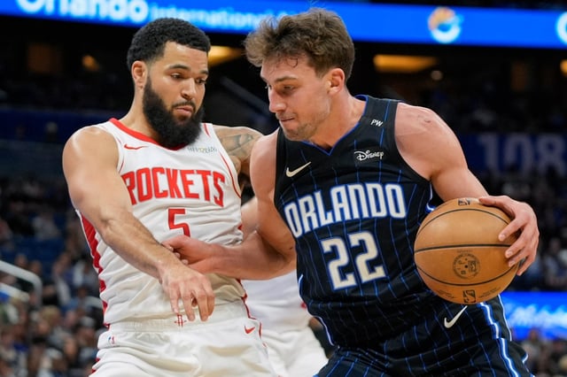 Orlando Magic forward Franz Wagner (22) pushes pst Houston Rockets guard Fred VanVleet (5) during the first half of an NBA basketball game, Wednesday, March 19, 2025, in Orlando, Fla. (AP Photo/John Raoux)