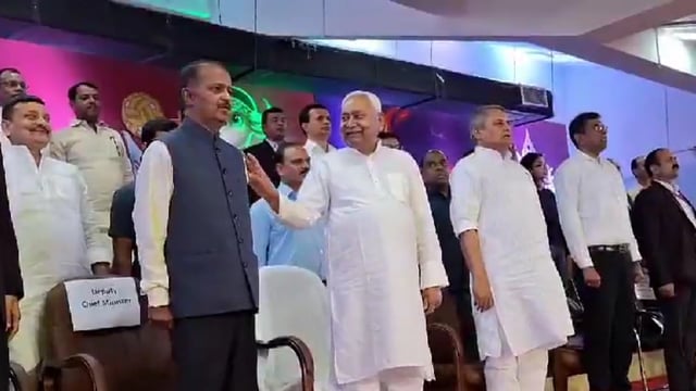 Bihar chief minister Nitish Kumar taps his principal secretary’s shoulder during the national anthem at a sports event in Patna.