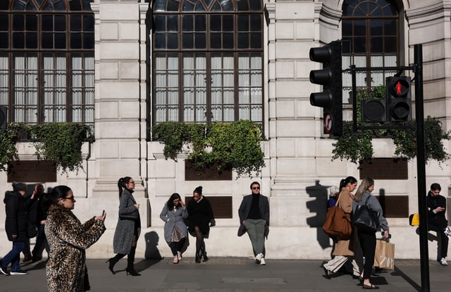 People walk and relax in the sunshine in the City of London financial district in London, Britain, March 4, 2025. REUTERS/Toby Melville/File Photo