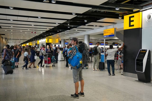 Des passagers font la queue à l’intérieur du terminal des départs de l’aéroport de Londres-Heathrow, Terminal 3, à Londres.