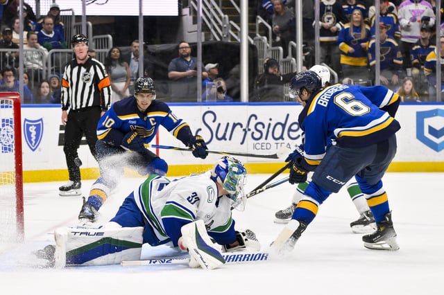 Mar 20, 2025; St. Louis, Missouri, USA;  St. Louis Blues defenseman Philip Broberg (6) shoots and scores the game winning goal against Vancouver Canucks goaltender Kevin Lankinen (32) in overtime at Enterprise Center. Mandatory Credit: Jeff Curry-Imagn Images