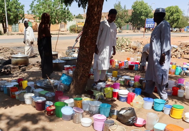 Sudanese men stand next to empty containers in front of "Takaya" the charity restaurant and a community kitchen, that helps the needy Sudanese in Omdurman areas recently controlled by army during the conflict and war, during the holy month of Ramadan in the state of Khartoum, Sudan March 14, 2025. REUTERS/El Tayeb Siddig/File Photo
