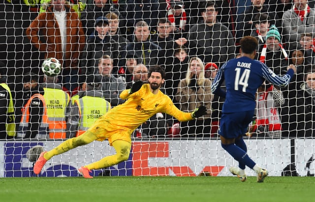 Soccer Football - Champions League - Round of 16 - Second Leg - Liverpool v Paris St Germain - Anfield, Liverpool, Britain - March 11, 2025 Paris St Germain's Desire Doue scores the penalty past Liverpool's Alisson Becker to win the shoot-out REUTERS/Peter Powell/File Photo