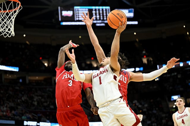 Mark Sears #1 of the Alabama Crimson Tide shoots the ball against Amarion Dickerson #3 and Ryan Prather Jr. #2 of the Robert Morris Colonials during the second half in the first round of the NCAA Men's Basketball Tournament  on March 21, 2025 in Cleveland, Ohio.