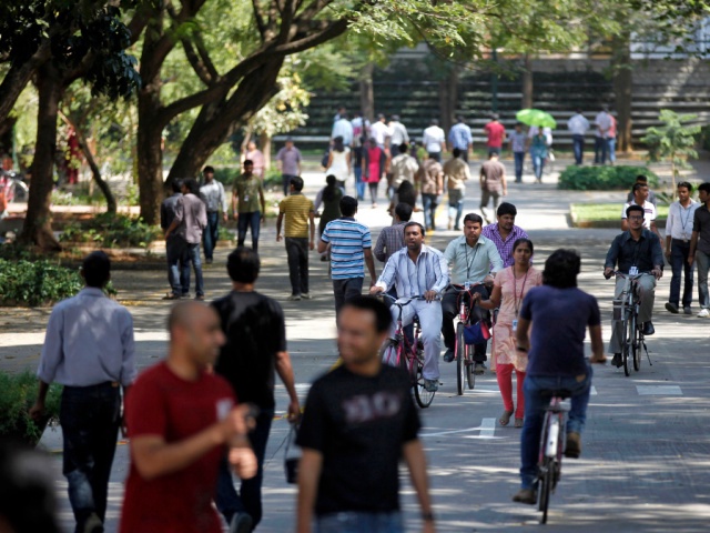 In this Jan. 11, 2013 file photo, employees of Infosys Technologies, the Indian technology outsourcing giant, move inside the company headquarters during a break after their quarterly financial results were announced in Bangalore, India. Speculation about tougher rules on so-called H-1B visas, used heavily by India’s massive technology and outsourcing industries to send programmers and other computer specialists to the United States, sent tech stocks tumbling in India early February, 2017, and compounded concerns about the protectionist direction of U.S. policy after President Donald Trump temporarily suspended immigration from seven Muslim-majority countries. (AP Photo/Aijaz Rahi, File)