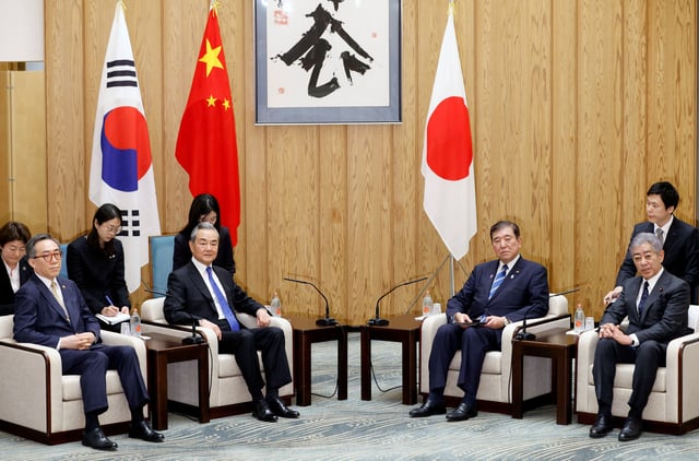 South Korean Foreign Minister Cho Tae-yul, Chinese Foreign Minister Wang Yi, Japanese Prime Minister Shigeru Ishiba and Foreign Minister Takeshi Iwaya sit at the start of their meeting at the prime minister’s official residence in Tokyo, Japan, 21 March 2025. FRANCK ROBICHON/Pool via REUTERS