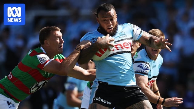Addin Fonua-Blake of the Sharks running with the ball, shrugging off a tackler