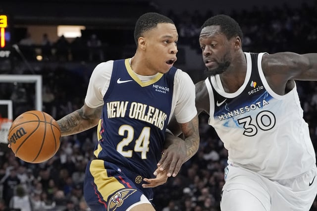 Mar 21, 2025; Minneapolis, Minnesota, USA; New Orleans Pelicans guard Jordan Hawkins (24) works around Minnesota Timberwolves forward Julius Randle (30) in the third quarter at Target Center. Mandatory Credit: Bruce Kluckhohn-Imagn Images