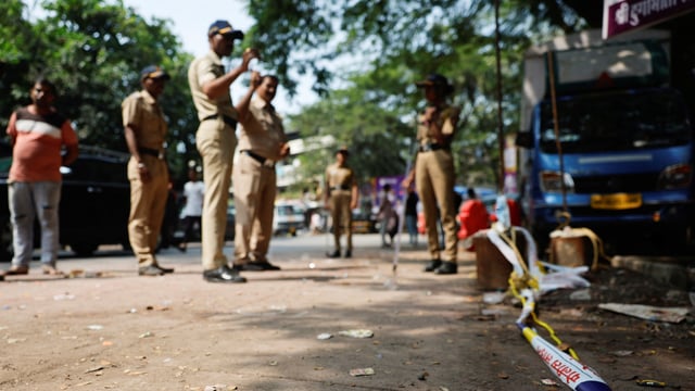 Police officers stand at the crime scene next to markings of the gunshots where Nationalist Congress Party (NCP) politician Baba Siddique was shot dead in Mumbai, India, October 13, 2024.