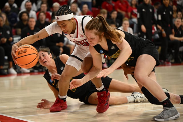 Mar 22, 2025; Raleigh, North Carolina, USA; NC State Wolfpack guard Zoe Brooks (35) reaches for a loose ball against Vermont Catamounts guard Keira Hanson (12) and Vermont Catamounts guard Bella Vito (10) during the second half at James T. Valvano Arena at William Neal Reynolds. William Howard-Imagn Images