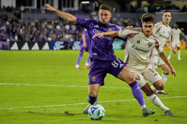Orlando City forward Marco Pasalic (87) tries to move the ball toward his goal as D.C. United midfielder Gabriel Pirani (right)  defends during the second half on Saturday night.  (AP Photo/John Raoux)