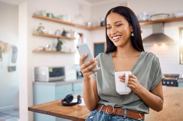 Stock image/file photo: A happy woman looking at her phone.