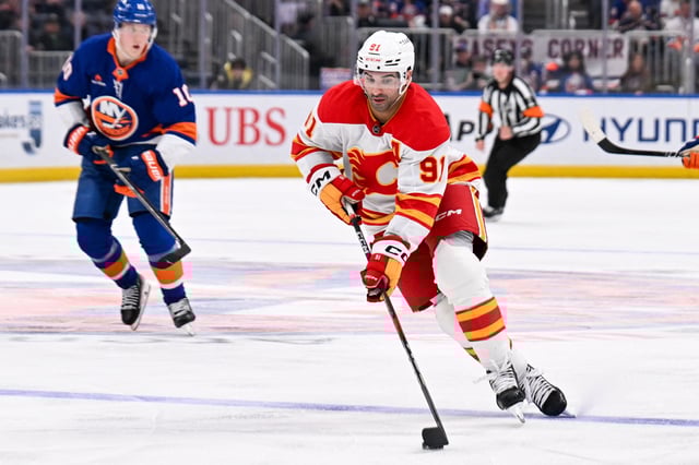 Mar 22, 2025; Elmont, New York, USA;  Calgary Flames center Nazem Kadri (91) skates across the blue line against the New York Islanders during the third period at UBS Arena. Mandatory Credit: Dennis Schneidler-Imagn Images