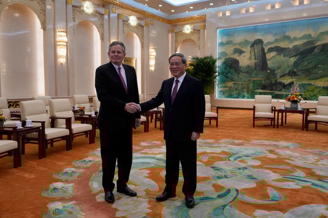 Chinese Premier Li Qiang, right, and U.S. Senator Steve Daines shakes hands for photos before a meeting in the Fujian Room at the Great Hall of the People in Beijing, China, Sunday, March 23, 2025.     Ng Han Guan/Pool via REUTERS