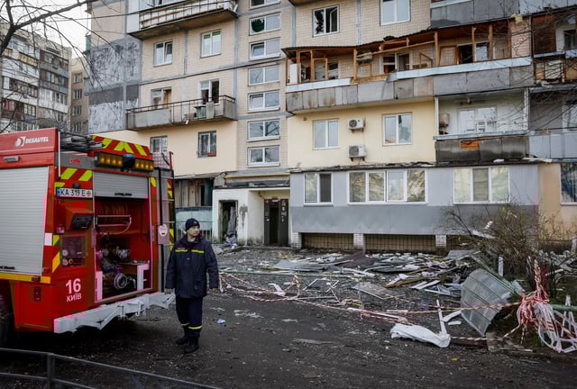 A firefighter works at a site of an apartment building hit by a Russian drone strike, amid Russia's attack on Ukraine, in Kyiv, Ukraine March 23, 2025. REUTERS/Gleb Garanich