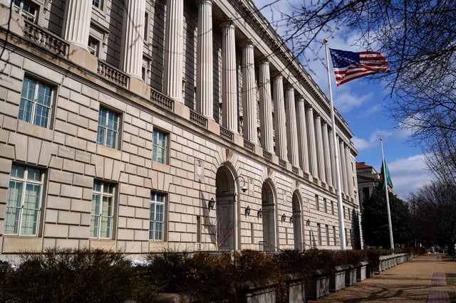 A U.S. flag flutters outside the U.S. Internal Revenue Service (IRS) building after it was reported the IRS will lay off about 6,700 employees, a restructuring that could strain the tax-collecting agency's resources during the critical tax-filing season, in Washington, D.C., February 20, 2025.
