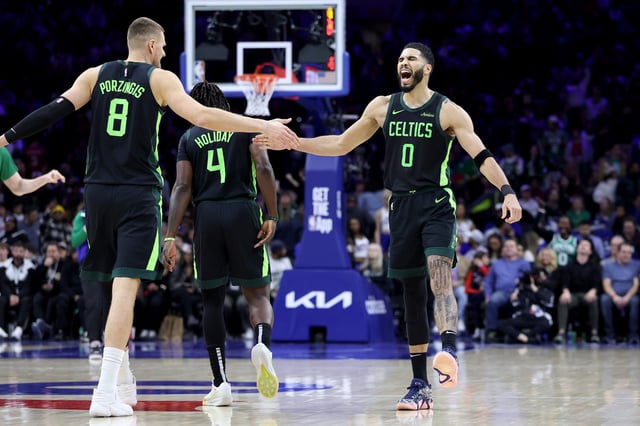 PHILADELPHIA, PENNSYLVANIA - FEBRUARY 02: Jayson Tatum #0 of the Boston Celtics celebrates a basket with Kristaps Porzingis #8 during the second half against the Philadelphia 76ers at the Wells Fargo Center on February 02, 2025 in Philadelphia, Pennsylvania.