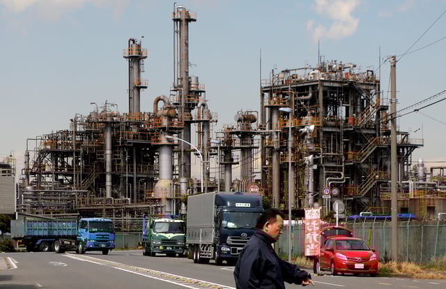 A worker walks near a factory at the Keihin industrial zone in Kawasaki, Japan, March 8, 2017. REUTERS/Toru Hanai/File Photo