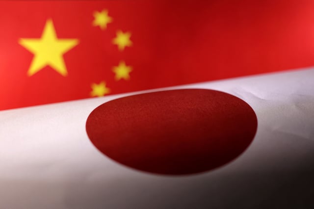 Printed Chinese and Japanese flags are seen in this illustration, July 21, 2022. REUTERS/Dado Ruvic/Illustration/File Photo
