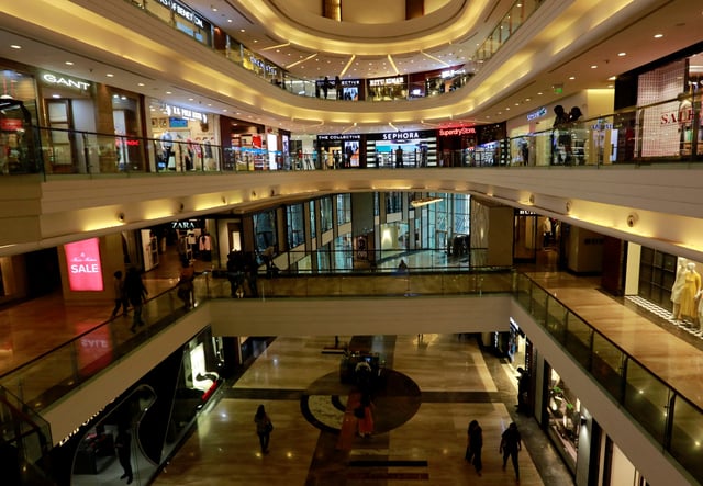 Shoppers walk past stores at a mall in Mumbai, India, July 10, 2017. Picture taken July 10, 2017. REUTERS/Danish Siddiqui/File Photo