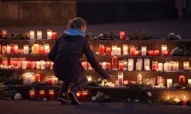 FILE - A school girl lights a candle in front of the Joseph-Koenig Gymnasium in Haltern, western Germany, March 24, 2015, after a Germanwings plane from Barcelona crashed on its way to Duesseldorf over the French alps. (AP Photo/Martin Meissner, File)
