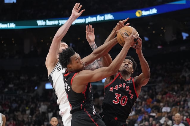Mar 23, 2025; Toronto, Ontario, CAN; Toronto Raptors guard Scottie Barnes (4) and forward Ochai Agbaji (30) battle with San Antonio Spurs forward Sandro Mamukelashvili (54) for the ball during the second half at Scotiabank Arena. Mandatory Credit: John E. Sokolowski-Imagn Images