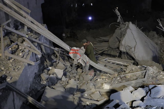 A Yemeni walks on debris from a destroyed building after it was struck by U.S. airstrikes in Sanaa, Yemen, Monday, March 24, 2025. (AP Photo)