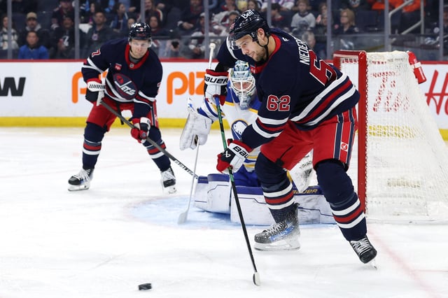 Mar 23, 2025; Winnipeg, Manitoba, CAN; Winnipeg Jets right wing Nino Niederreiter (62) receives a pass in front of Buffalo Sabres goaltender James Reimer (47) in the second period at Canada Life Centre. Mandatory Credit: James Carey Lauder-Imagn Images