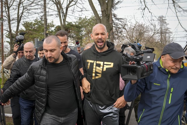 Andrew Tate reacts while speaking to media after checking in at a police station as part of his judicial control, which requires him to appear before judicial authorities in Romania when summoned, after returning from the United States, in Voluntari, Romania, Monday, March 24, 2025. (AP Photo/Vadim Ghirda)
