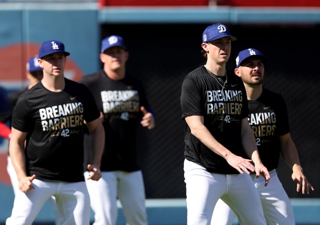 Ryan Yarbrough #56, Evan Phillips #59 and Alex Vesia #51 of the Los Angeles Dodgers run drills before the game against the Washington Nationals on Jackie Robinson Day at Dodger Stadium on April 15, 2024 in Los Angeles, California.