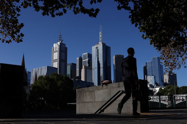 A commuter walks along the Yarra River in view of the Central Business District (CBD), in Melbourne, Australia, March 24, 2025. REUTERS/Hollie Adams/File Photo