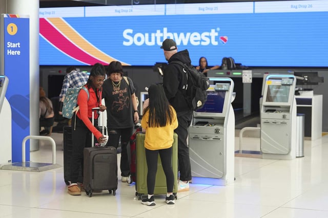 Passengers check in at a kiosk at the tocketing counter for Southwest Airlines. The airline is set to cut jobs at four major U.S. airports, including one in the Bay Area, as part of a cost-cutting initiative. 