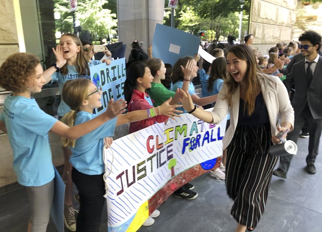 FILE - Kelsey Juliana, of Eugene, Ore., greets climate supporters outside a federal courthouse, June 4, 2019, in Portland, Ore. (AP Photo/Andrew Selsky, File)