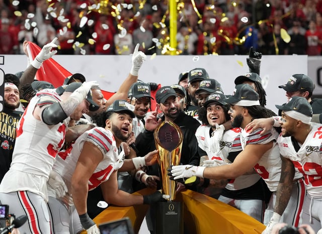 Jan 20, 2025; Atlanta, GA, USA; Ohio State Buckeyes head coach Ryan Day and his team celebrate with the CFP National Championship trophy after defeating the Notre Dame Fighting Irish in the CFP National Championship college football game at Mercedes-Benz Stadium. Mandatory Credit: Kirby Lee-Imagn Images/File Photo