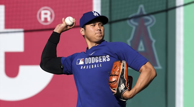 Dodgers star Shohei Ohtani throws in the outfield before their Freeway Series exhibition game against the Angels on Monday at Angel Stadium. Ohtani will throw his first bullpen session in more than a month on Saturday. (AP Photo/Kevork Djansezian)