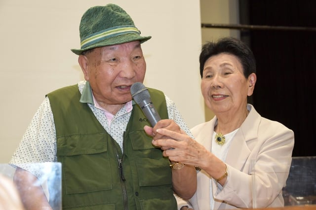 This photo taken in September 2024 shows Iwao Hakamada (L) speaking as his 91-year-old sister Hideko holds the microphone