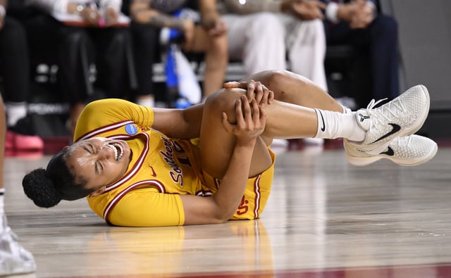 Mar 24, 2025; Los Angeles, California, USA; USC Trojans guard JuJu Watkins (12) grabs her knee after falling to the floor during an NCAA Tournament second round game against the Mississippi State Bulldogs at Galen Center. Mandatory Credit: Robert Hanashiro-Imagn Images