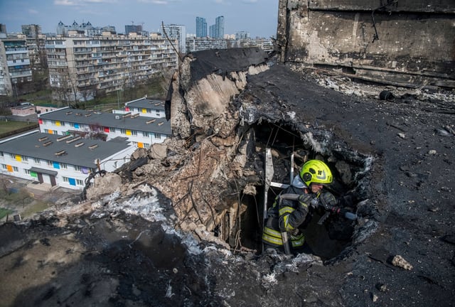 A firefighter works at a site an apartment building hit by a Russian drone strike, amid Russia's attack on Ukraine, in Kyiv, Ukraine March 23, 2025. REUTERS/Vladyslav Musiienko/File Photo